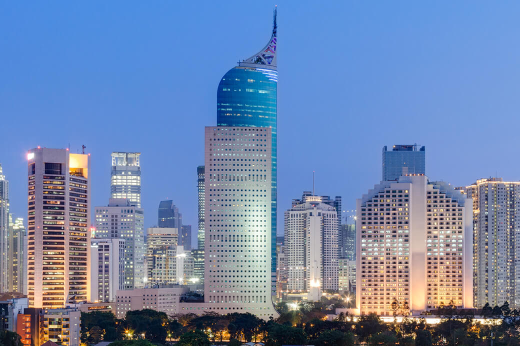 Illuminated city skyline featuring prominent modern skyscrapers.
