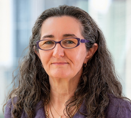 Professional headshot of Fiona Trafford-Walker, wearing glasses and a purple jacket, against a softly blurred office background.